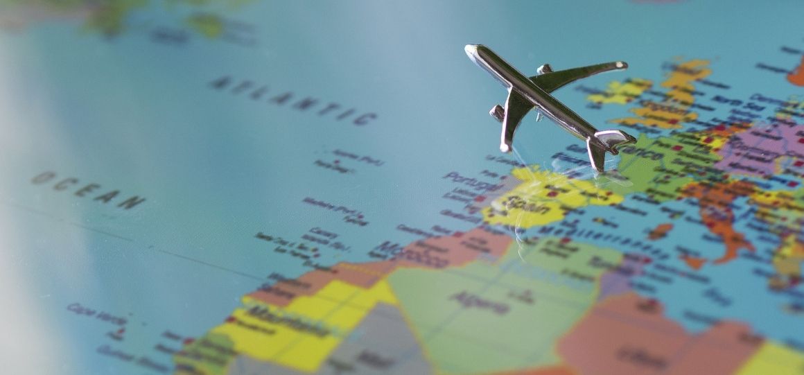 figurine d'avion au dessus d'une map monde